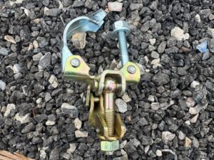 Close-up of drop forged prop to tube double coupler showing T-bolt and nut
