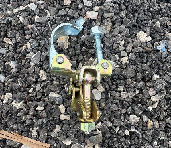 Close-up of drop forged prop to tube double coupler showing T-bolt and nut