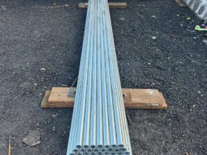 Bundle of new 16ft galvanised steel scaffold tubes 48.3mm diameter laid out on ground