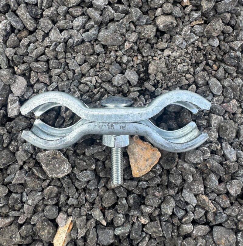 Top-down view of Heras fence coupler clamp on gravel surface