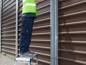 Compact aluminium work platform in use providing stable low-level access for maintenance work on exterior building