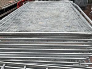 Stacked galvanised Heras temporary fencing panels ready for delivery