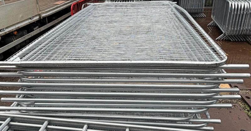 Stacked galvanised Heras temporary fencing panels ready for delivery