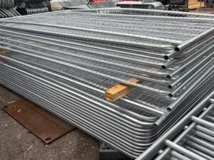 Galvanised Heras temporary fencing panels stacked in the yard